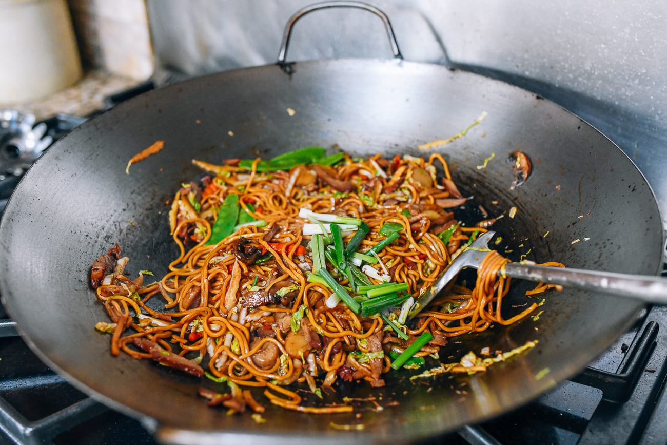 Adding snow peas and scallions to lo mein