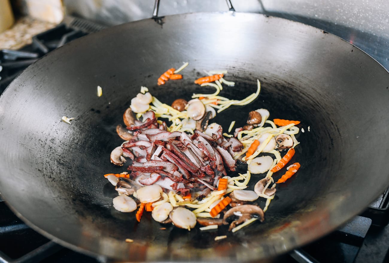 Adding julienned Chinese bbq pork to vegetables in wok