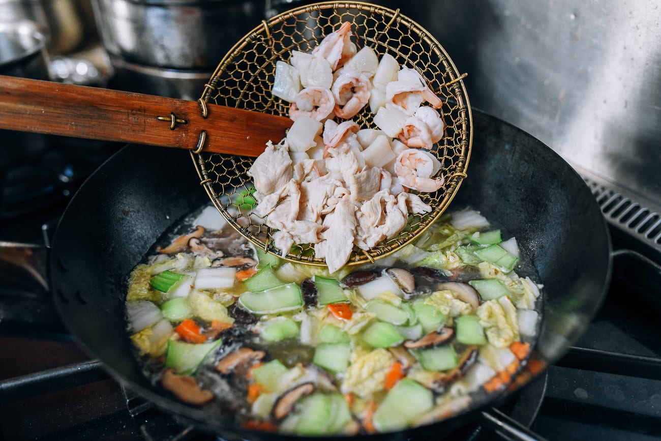 Adding cooked shrimp, scallops, and chicken to soup
