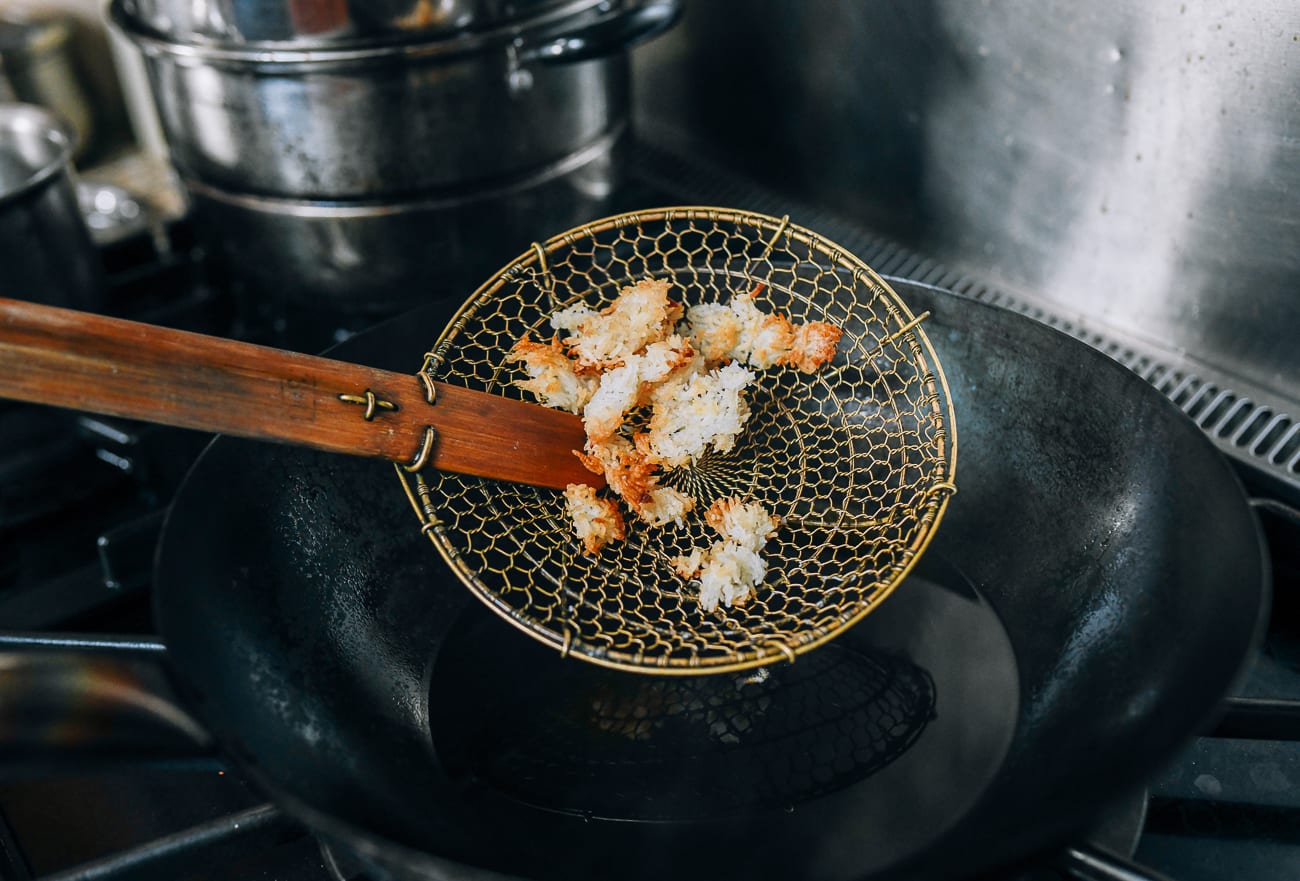 Removing rice with strainer from hot oil