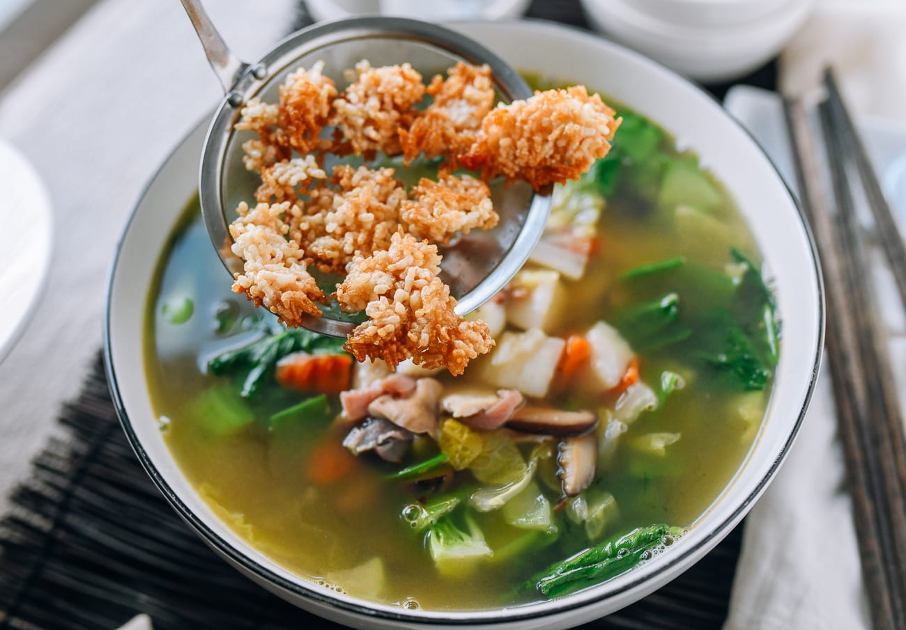 Putting crispy fried rice onto hot soup