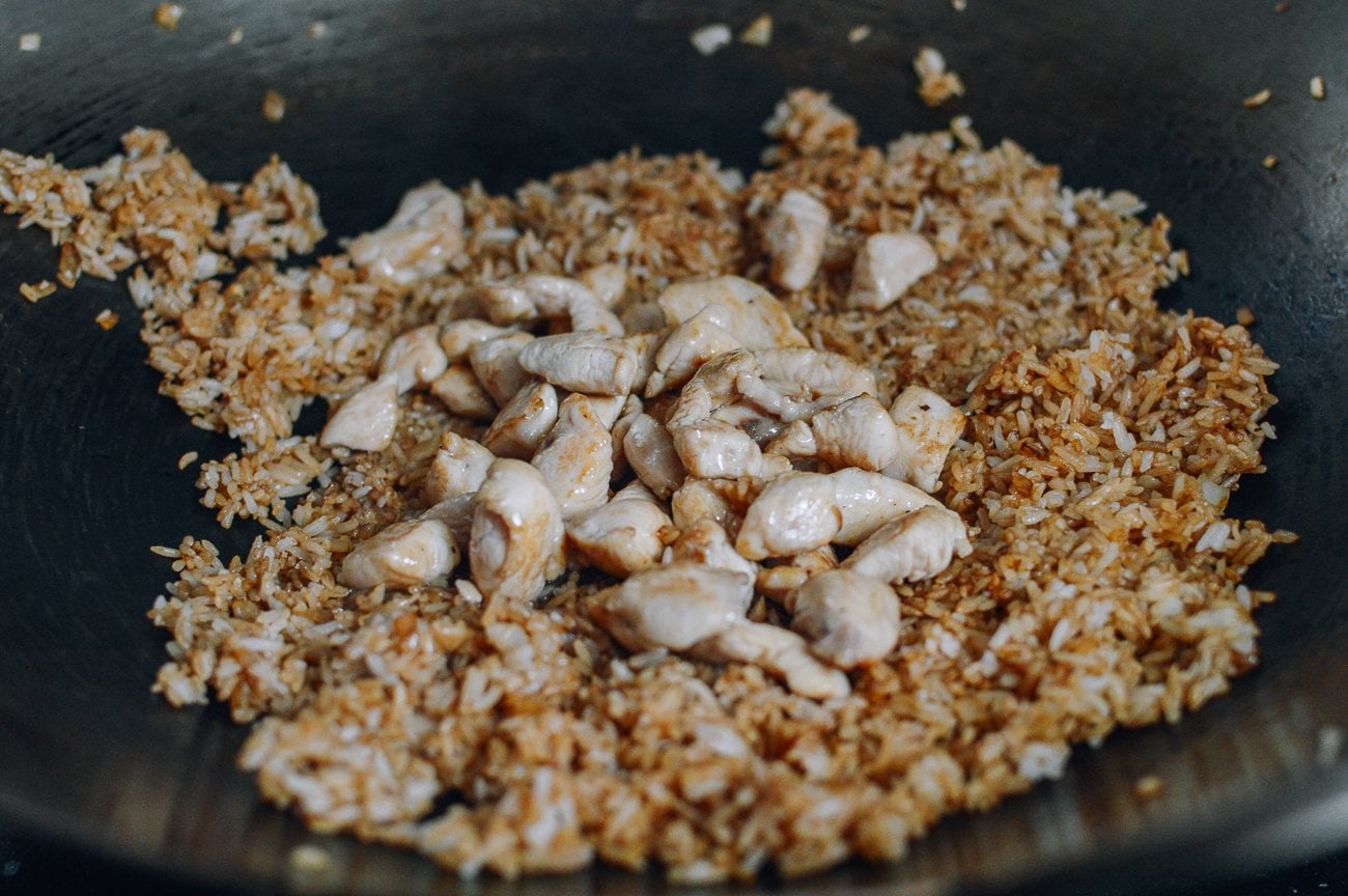 Adding chicken to fried rice in wok