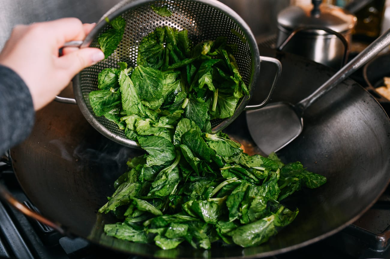 Adding pea tips to wok