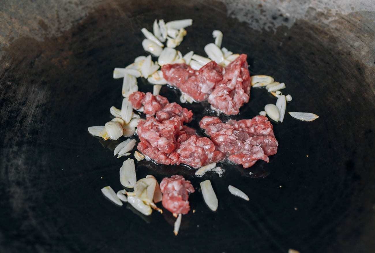 Ground pork added to garlic
