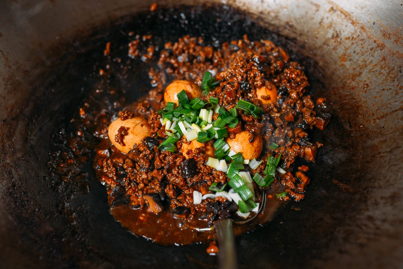 Adding scallions to meat and egg mixture