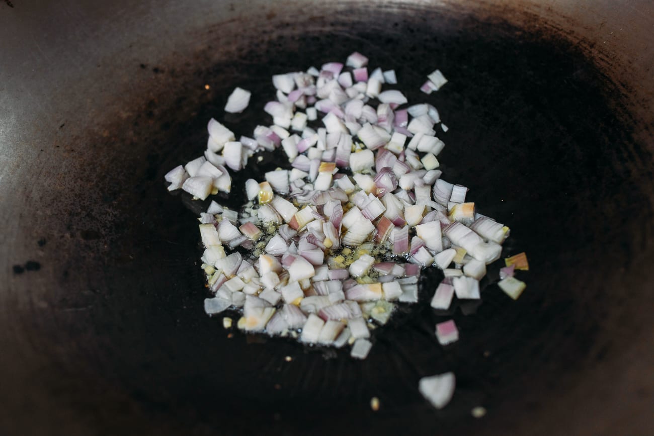 Adding shallots to wok