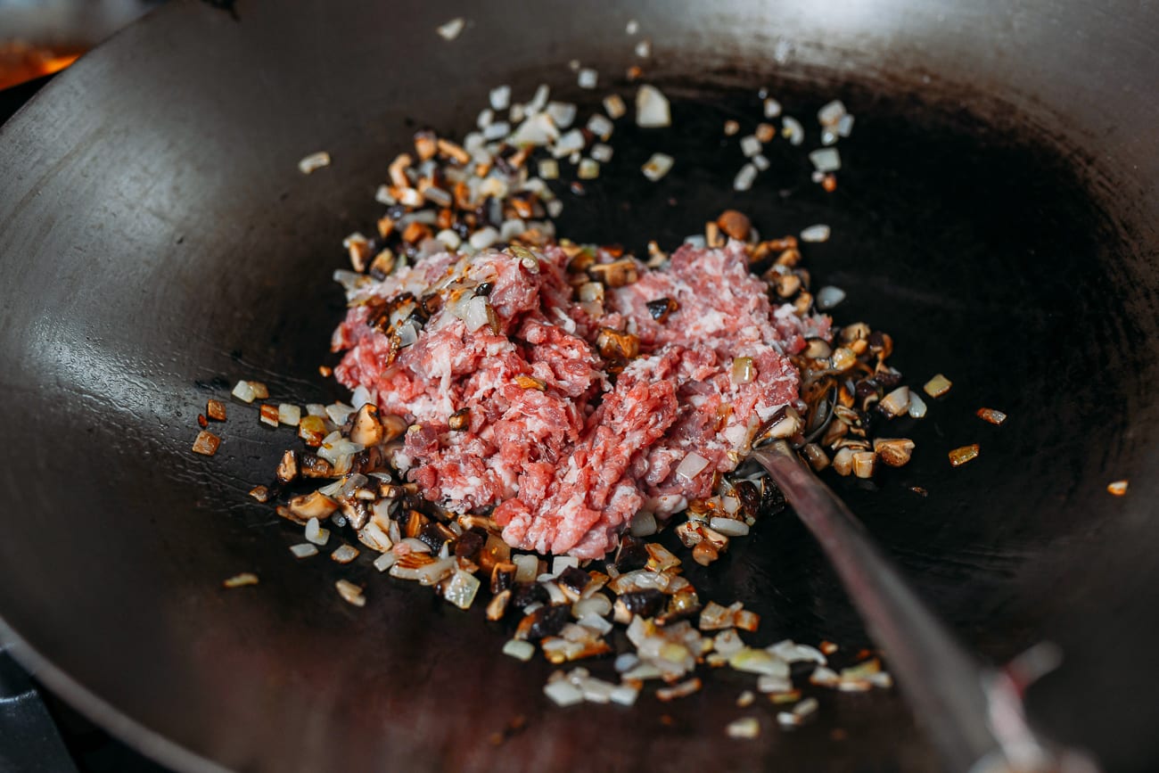 Adding ground pork to mushroom and shallot mixture