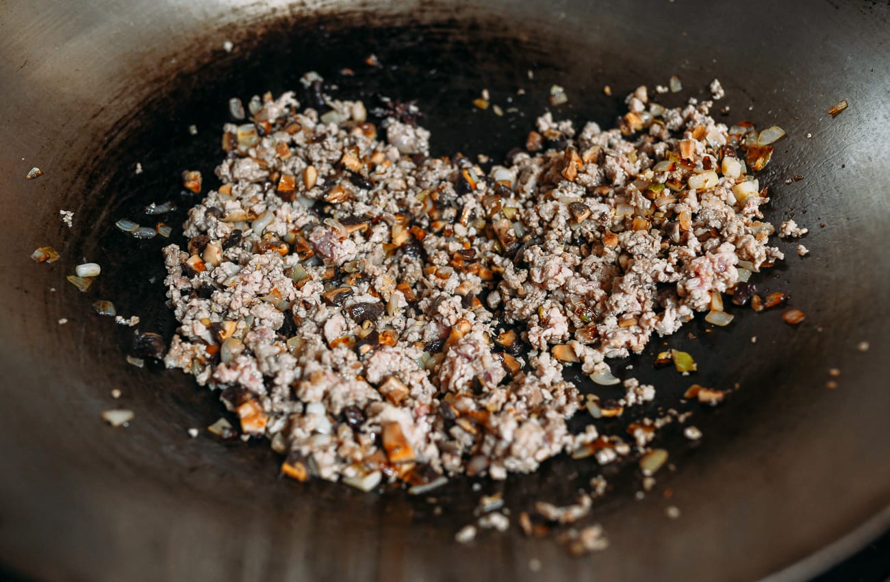 Cooked ground pork in wok with mushrooms and shallots