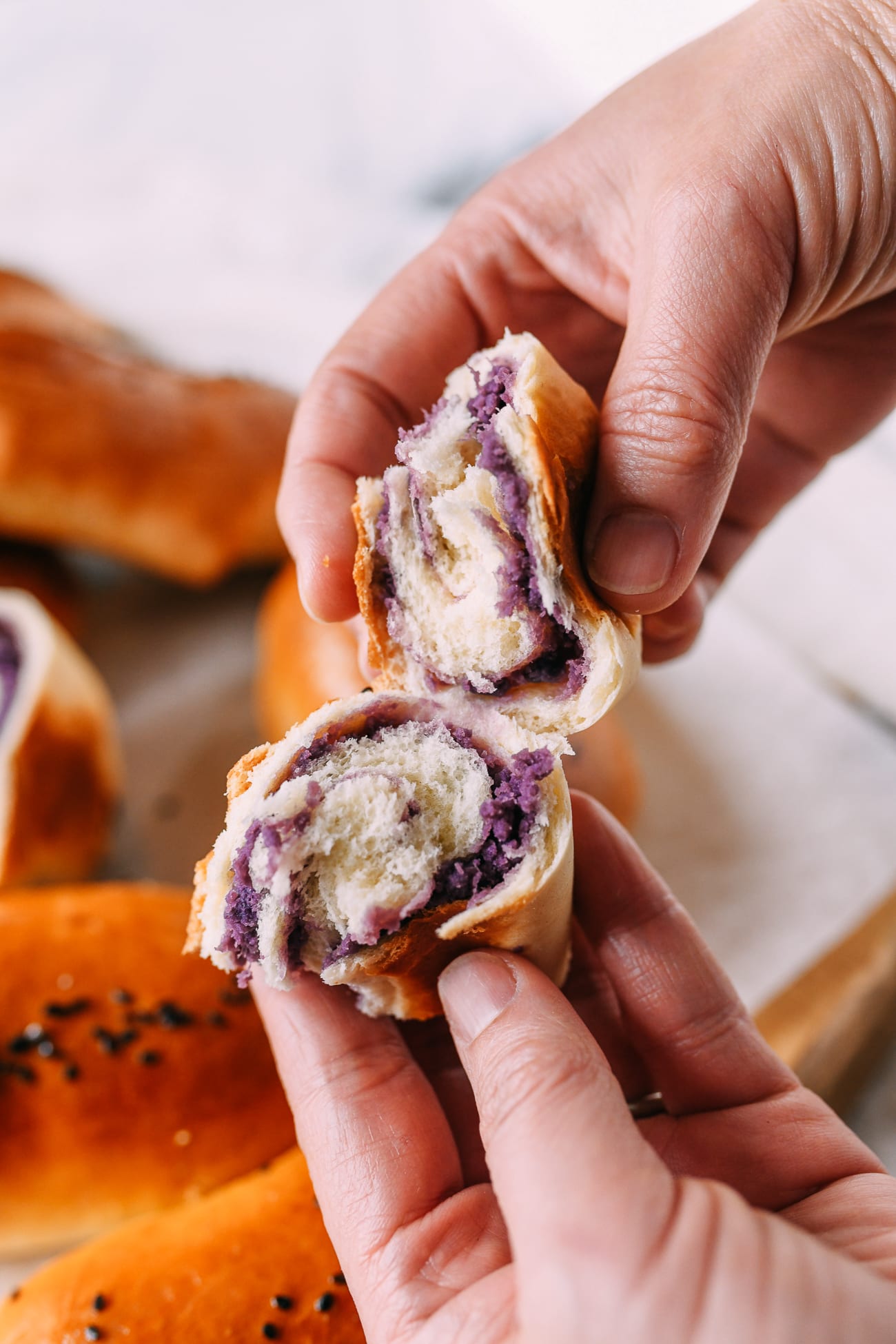 Ripping open an ube bun with two hands