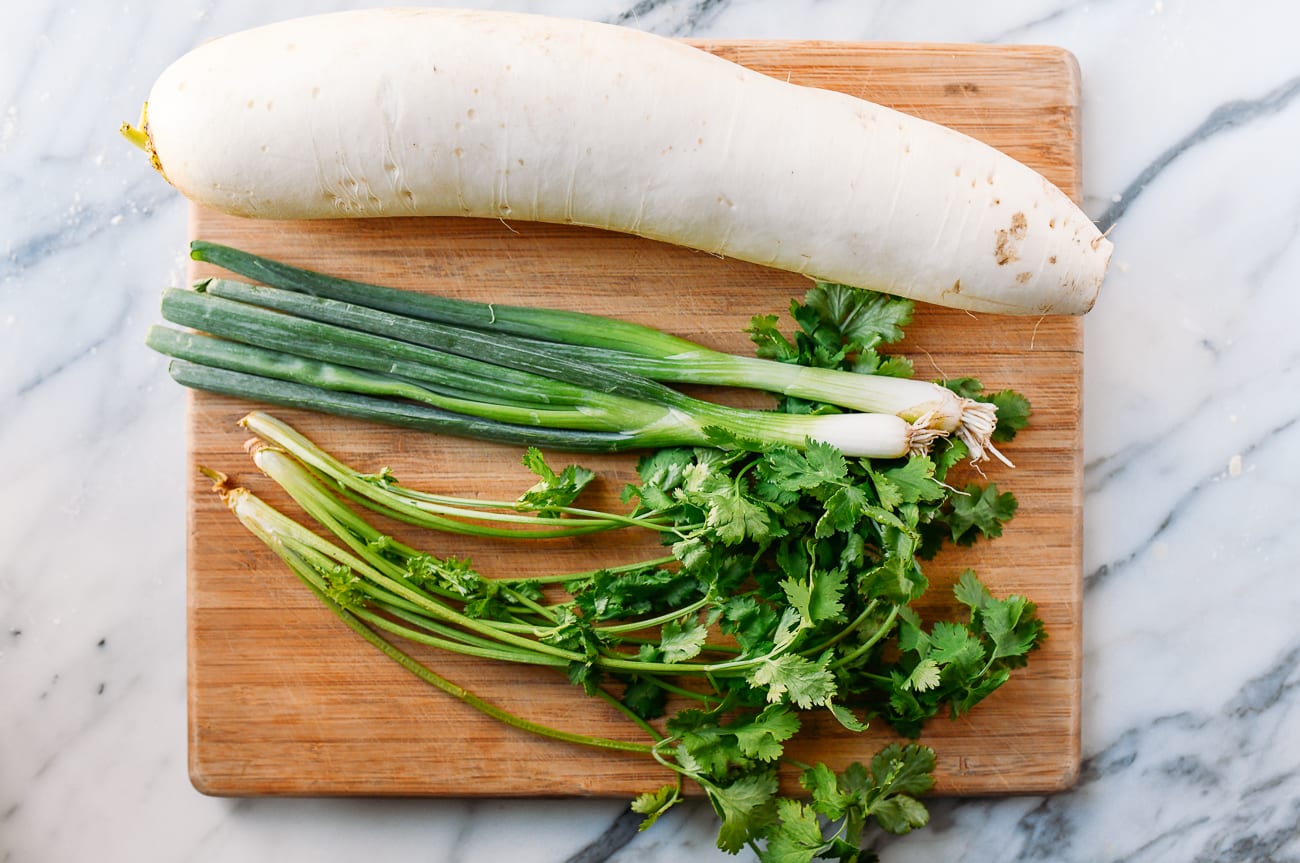 daikon radish, scallions, and cilantro on cutting board