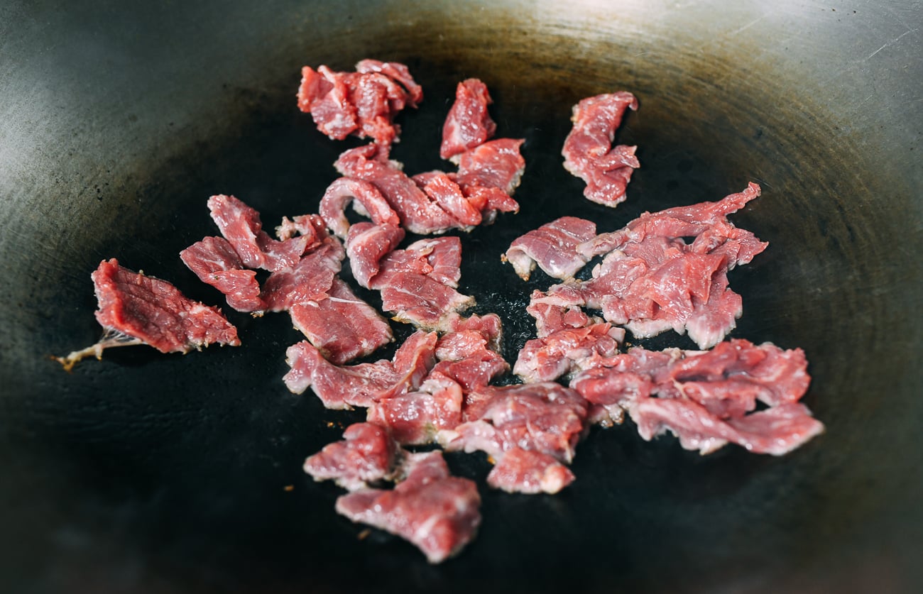 Searing marinated flank steak in wok