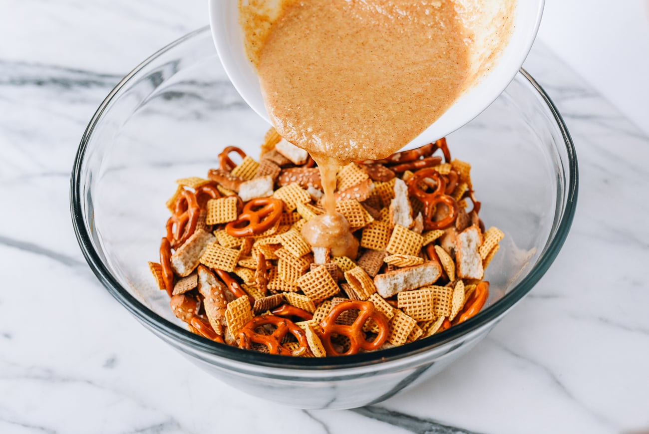Drizzling marinade over snack mix