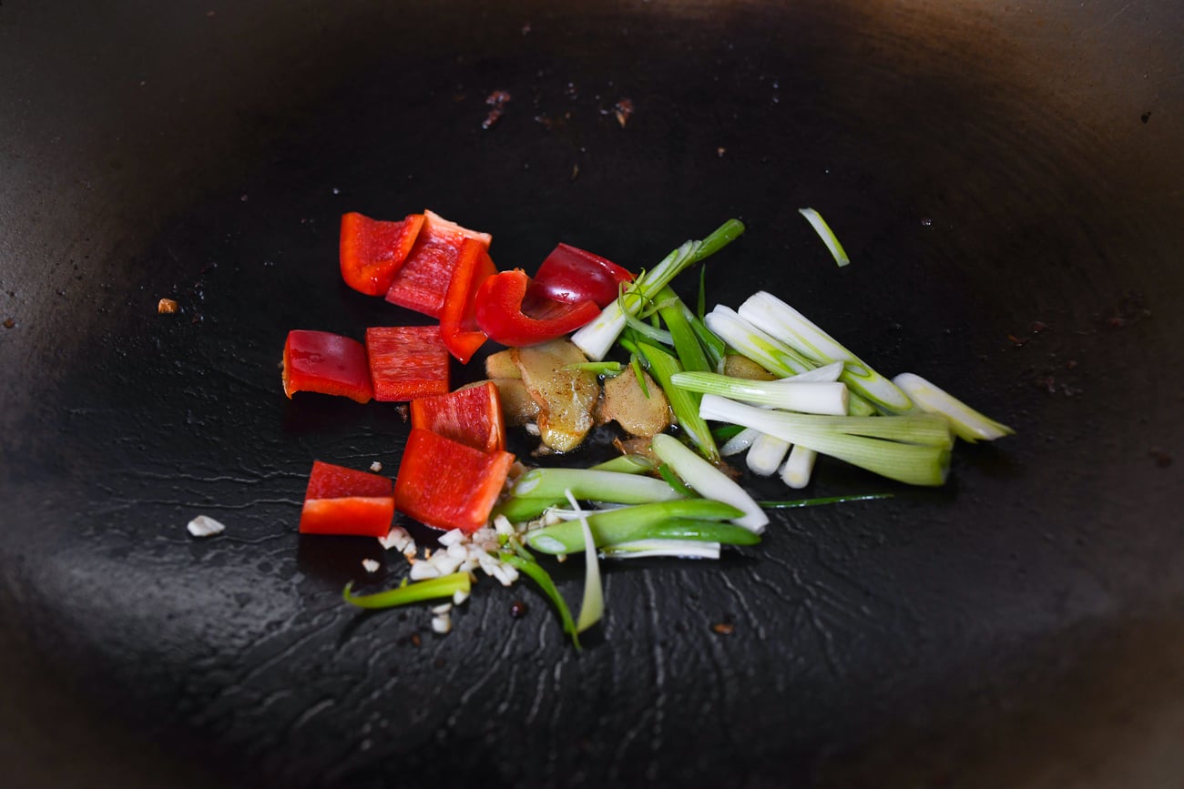 Scallions, ginger, and bell pepper in wok