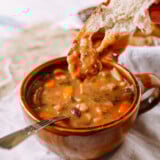 Dipping bread into ham and bean soup