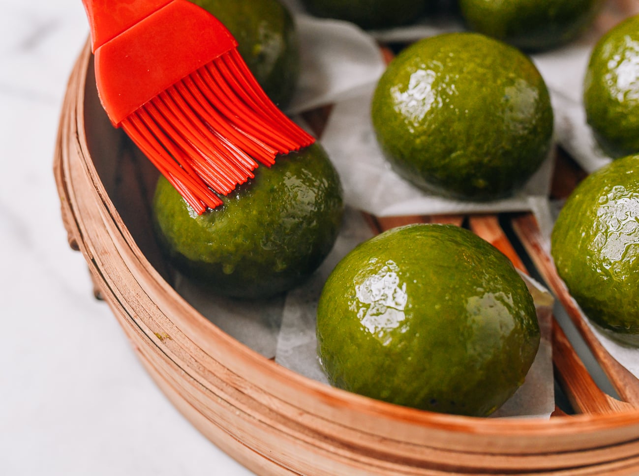Brushing steamed qingtuan with oil
