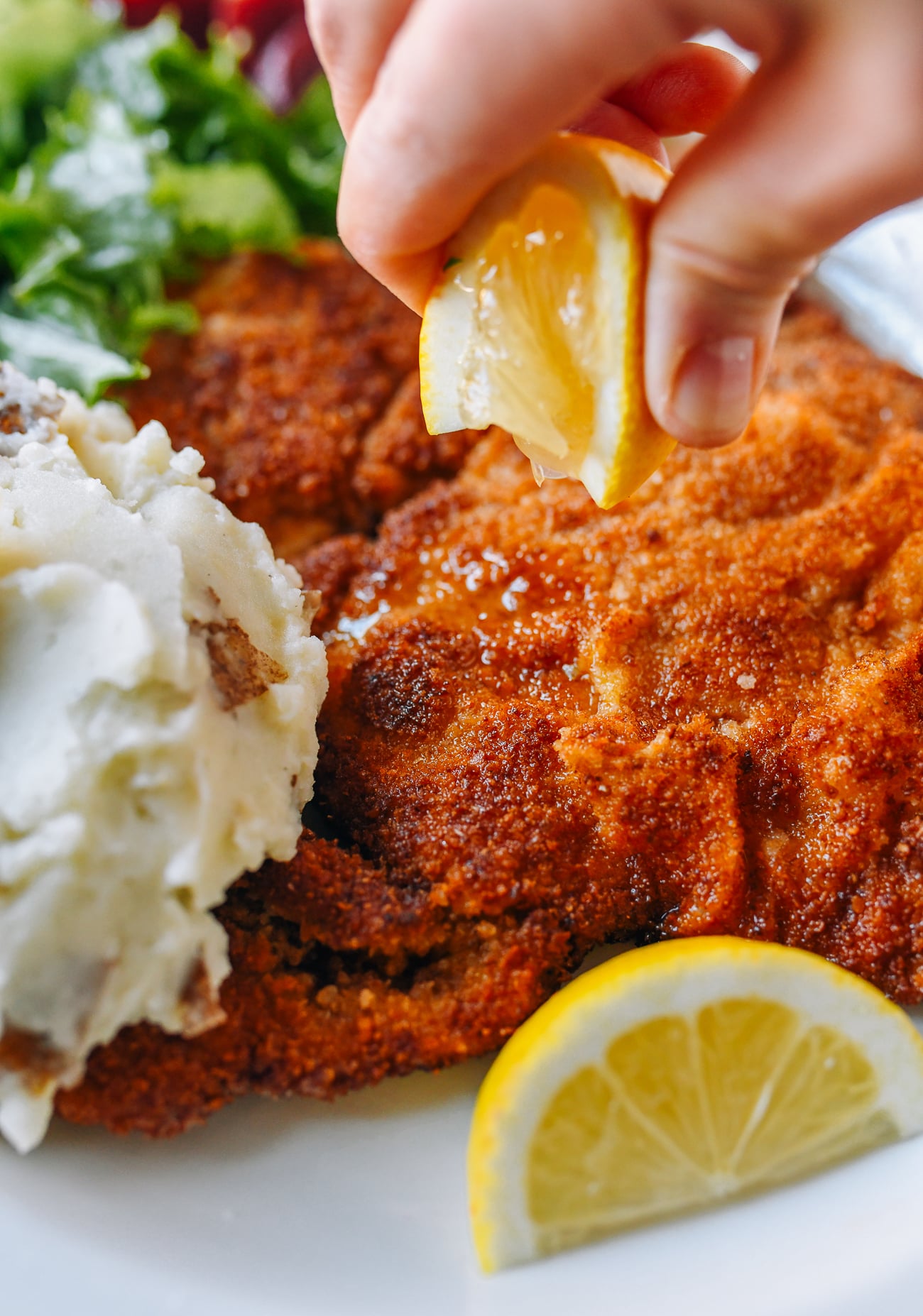 Squeezing lemon onto schnitzel