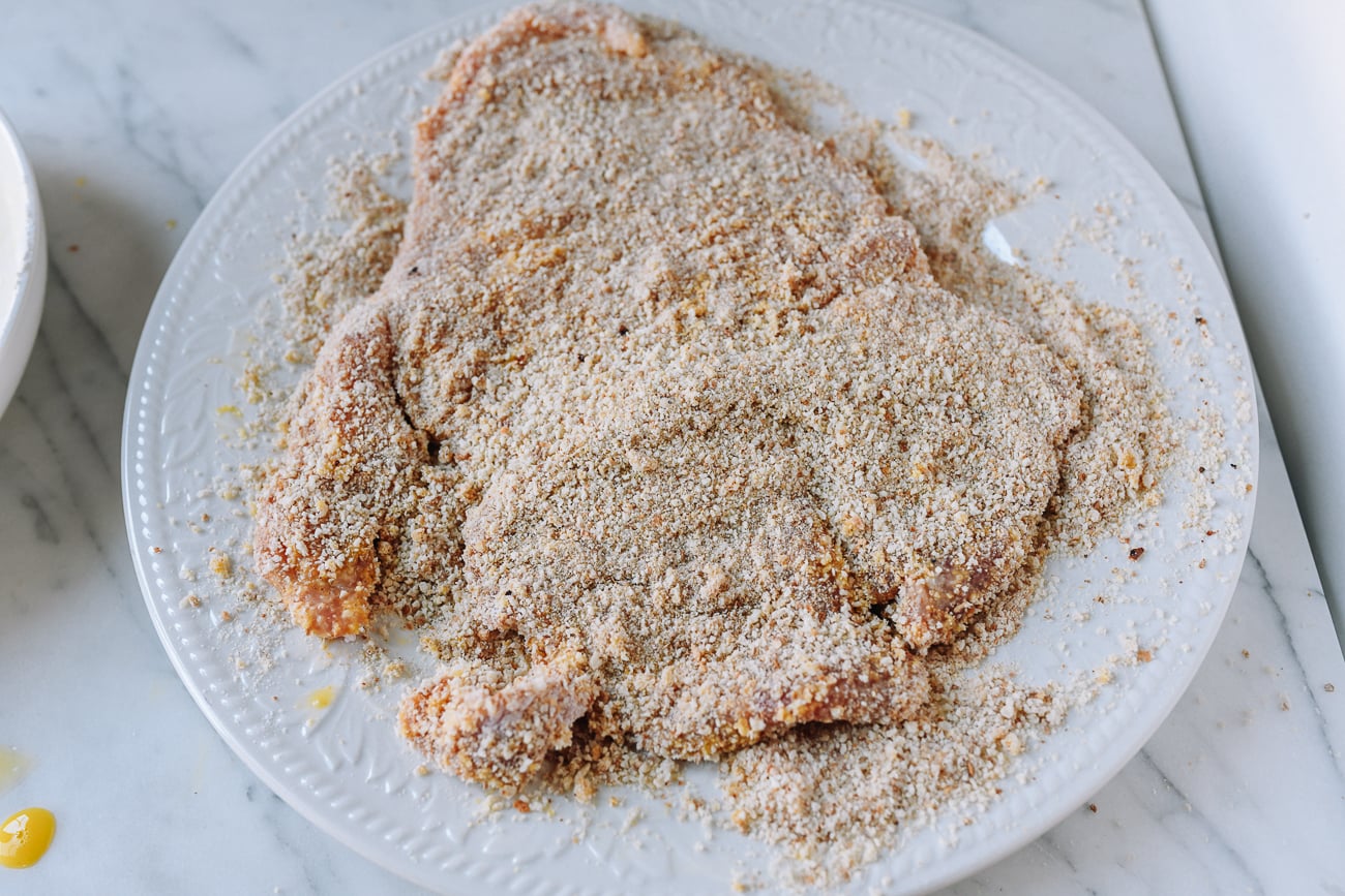 Coating pork chop in breadcrumbs