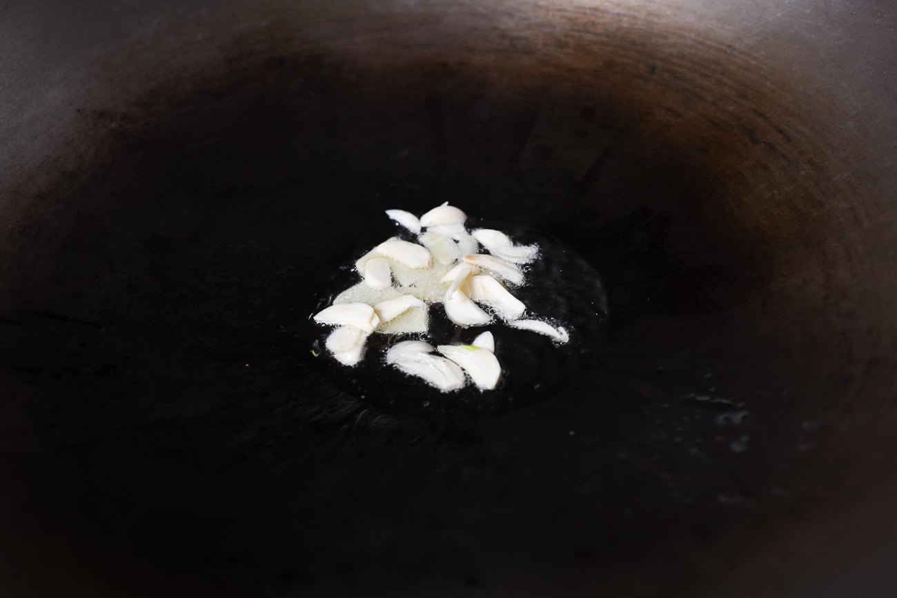 Adding garlic to ginger in wok