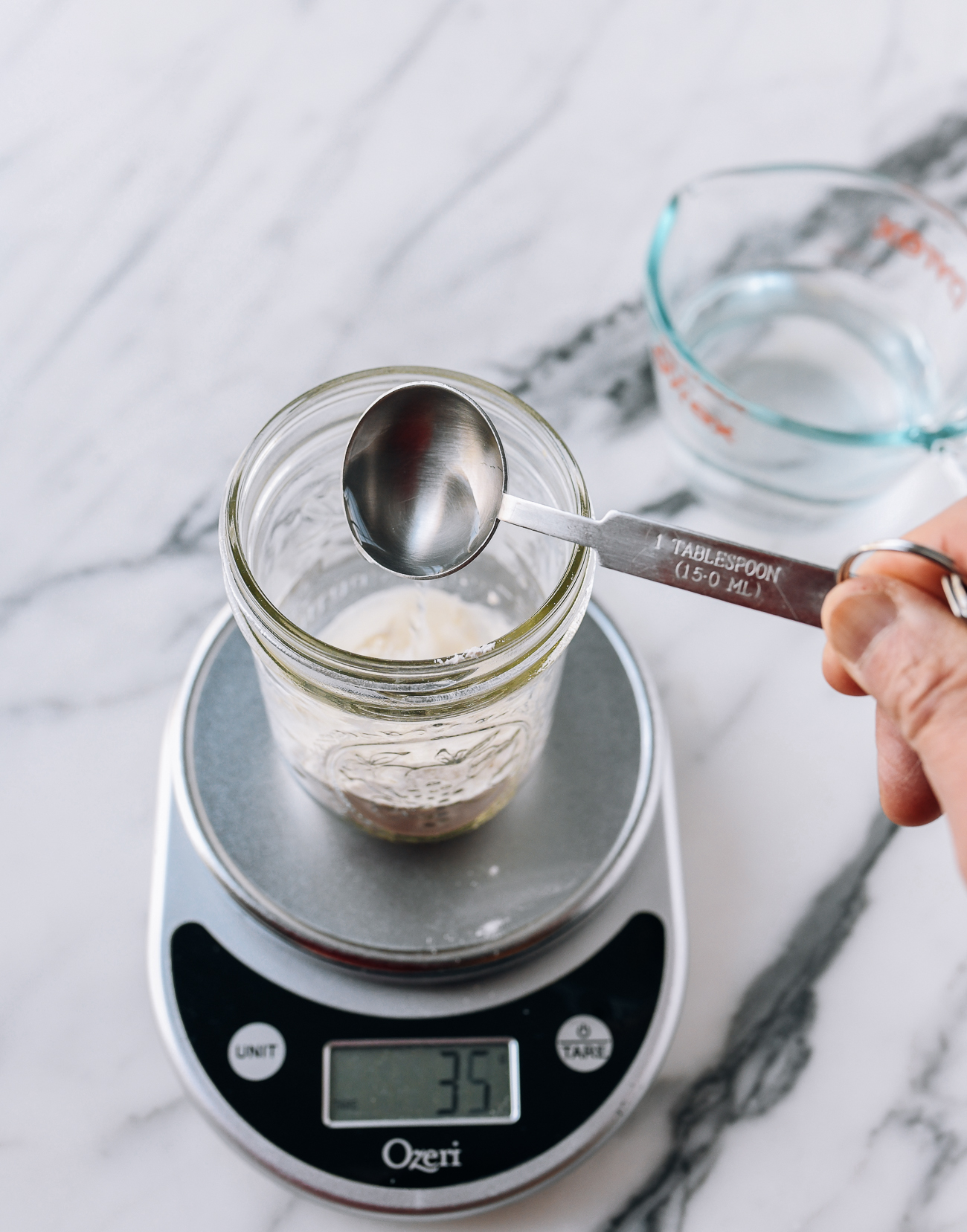 Adding 35g water to flour in jar