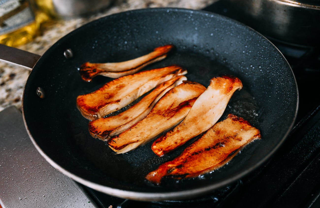 Browned king oyster mushroom slices in pan