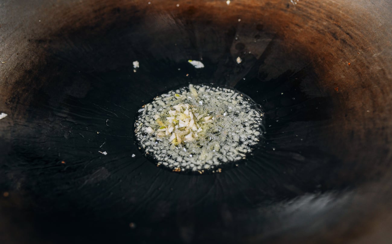 Adding garlic to oil and ginger