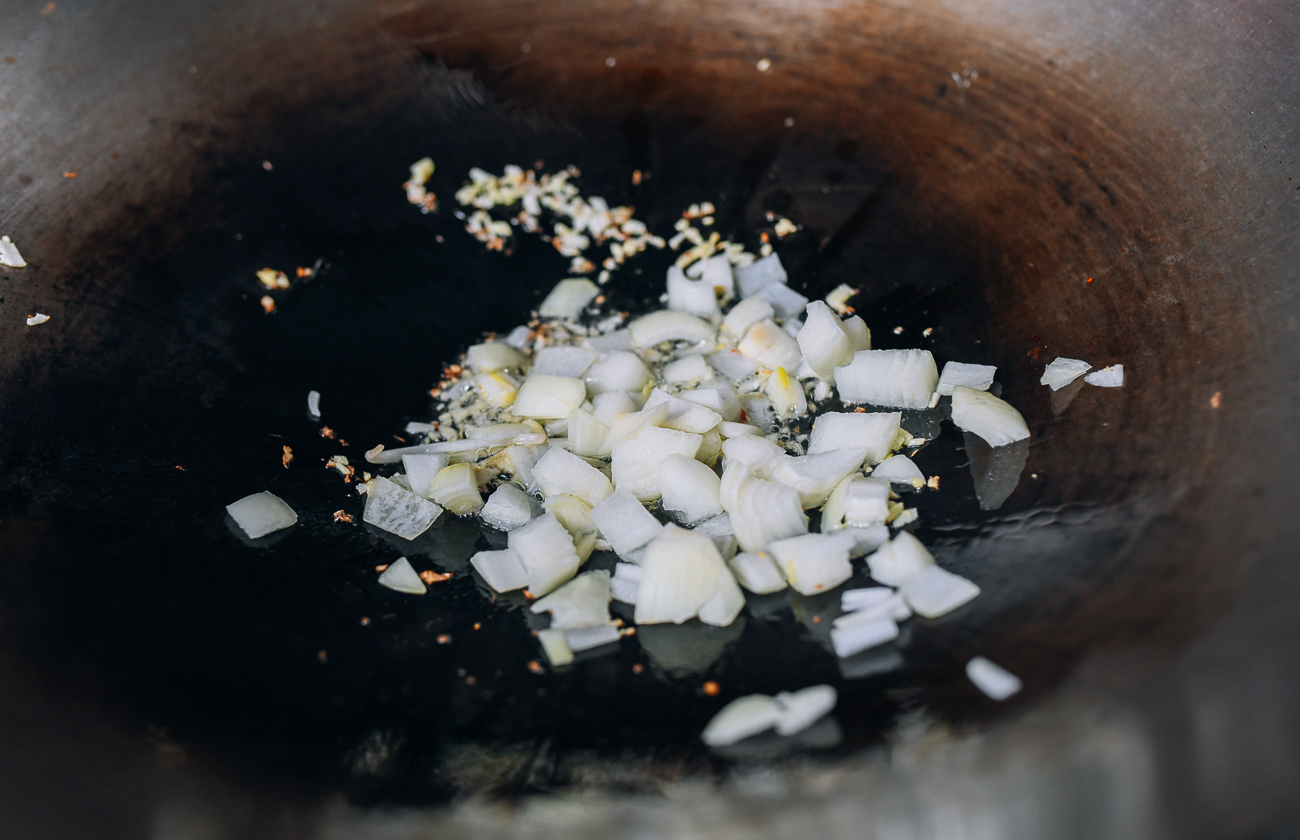 Adding onions to ginger and garlic