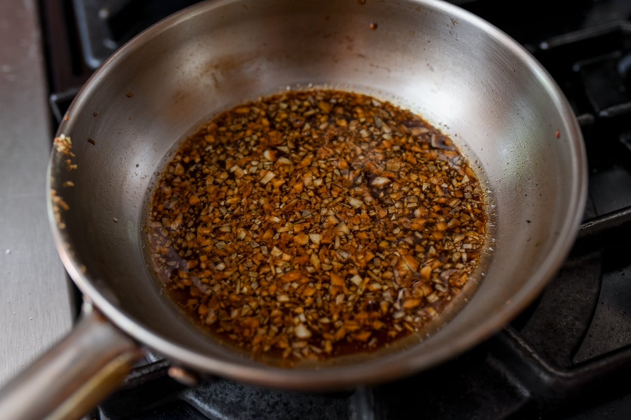 Garlic, oyster sauce, soy sauce, oil, and water in pan