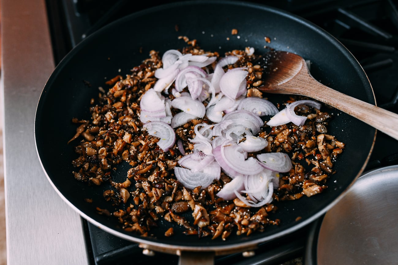 Adding shallots to pan of mushrooms