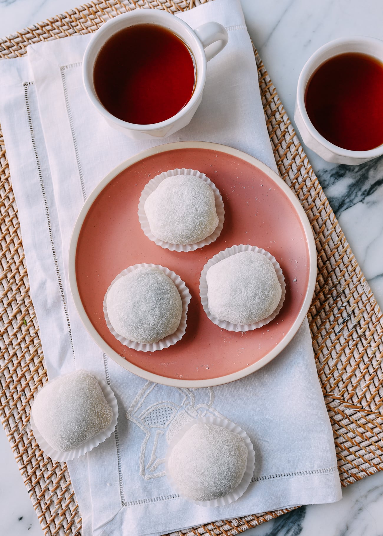 Mochi balls in paper cups on pink plate
