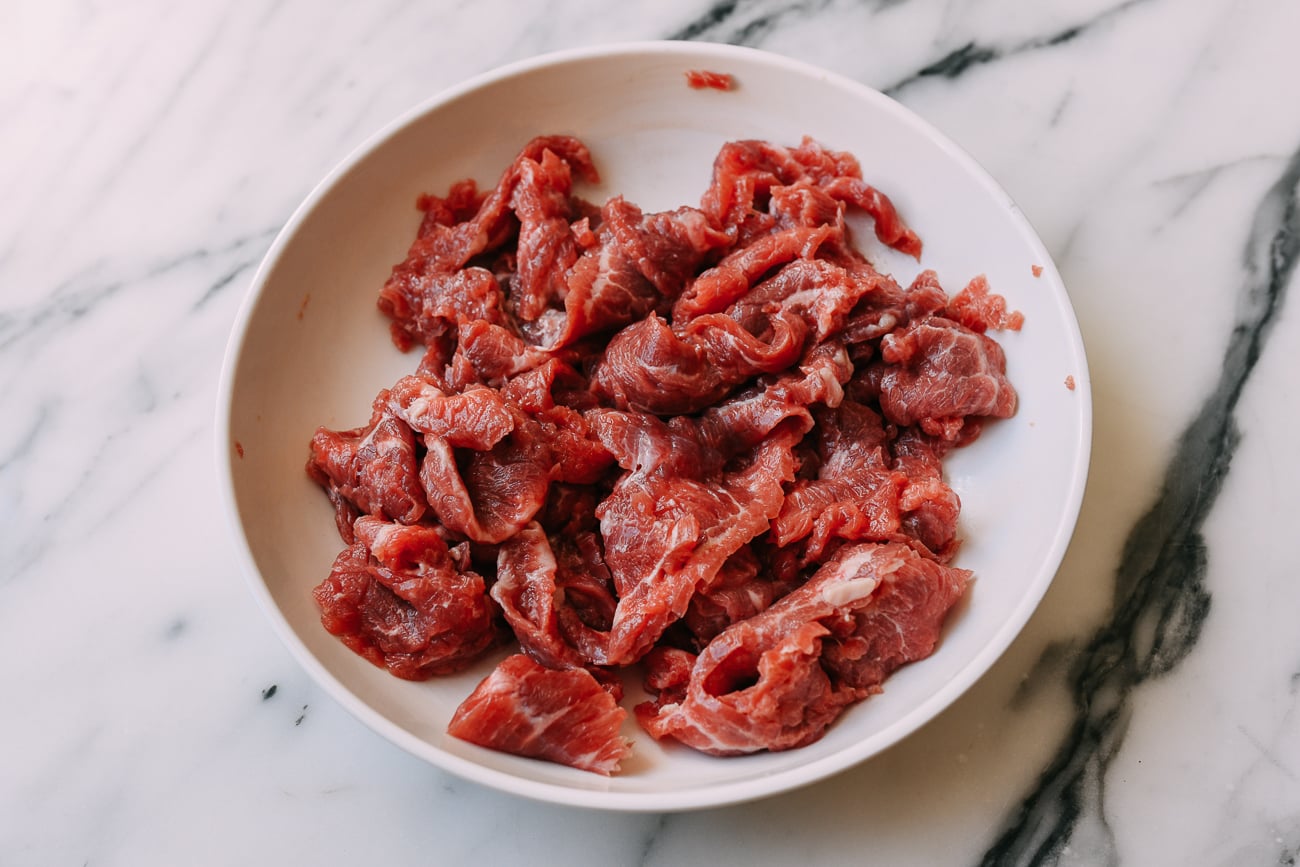 Marinating thinly sliced beef.