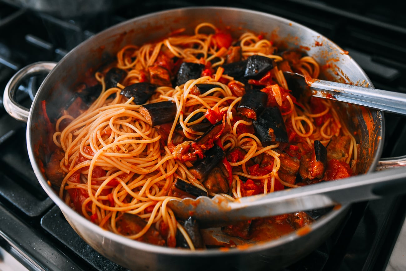 Tossing pasta alla norma in pan