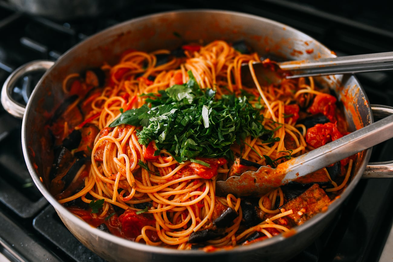 Adding chopped parsley and basil to pasta