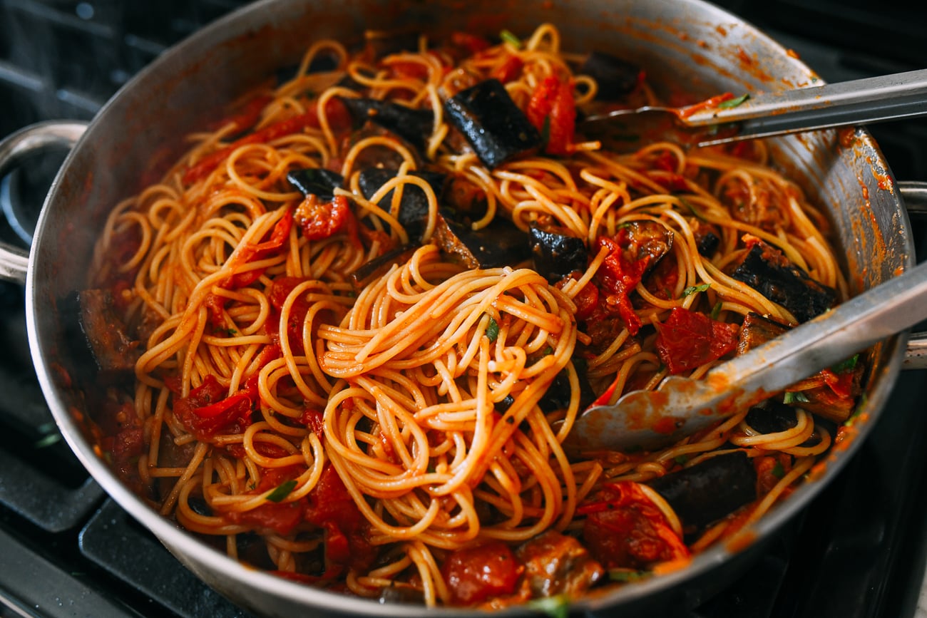 Tossing pasta alla norma together before serving