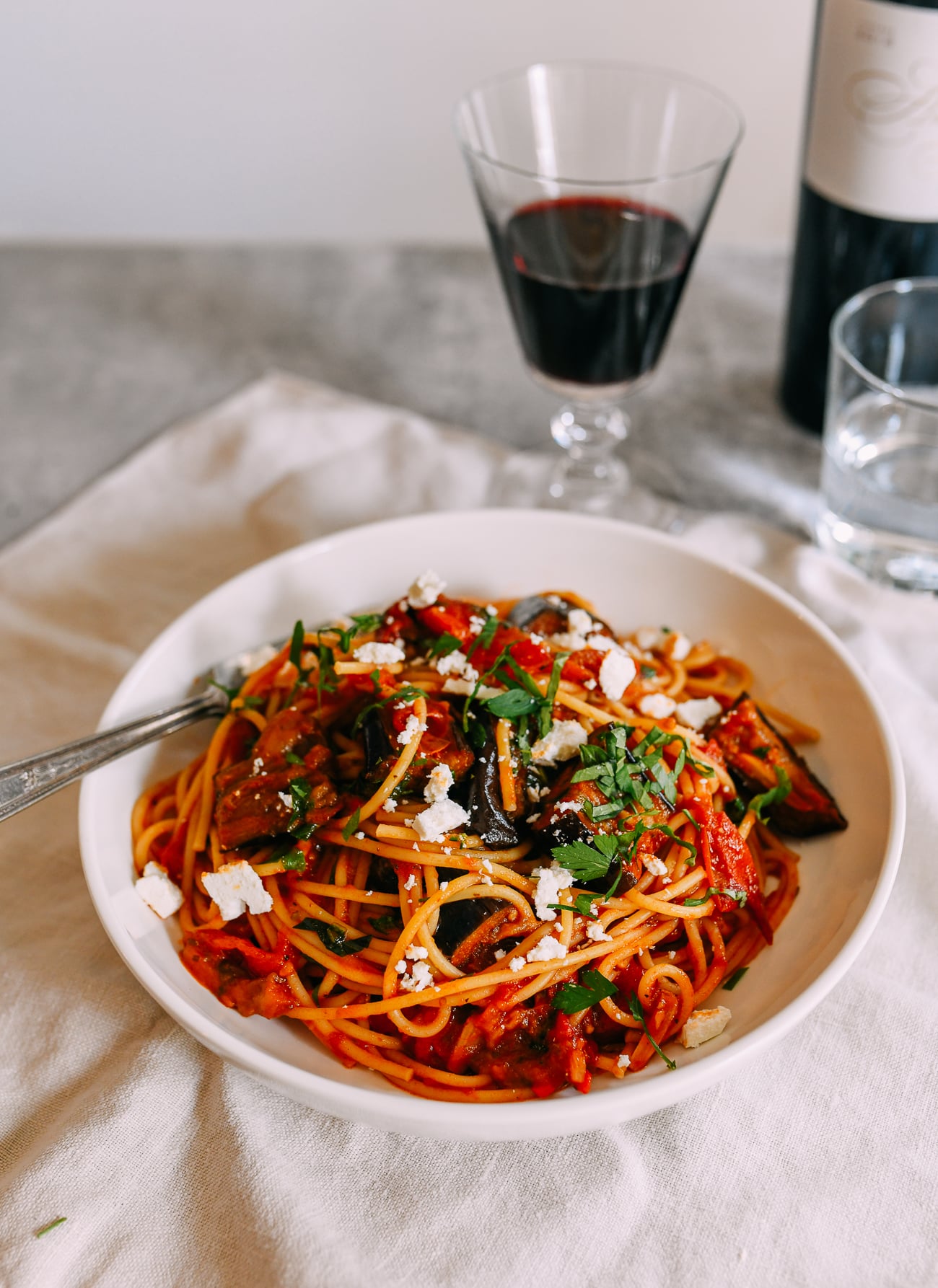 Pasta alla norma served with red wine