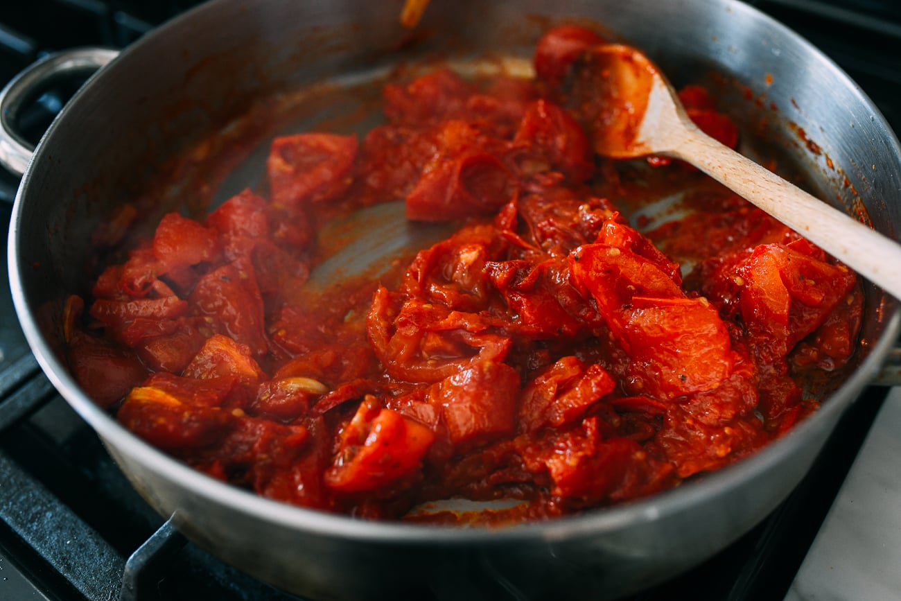 Adding roasted tomatoes to pan