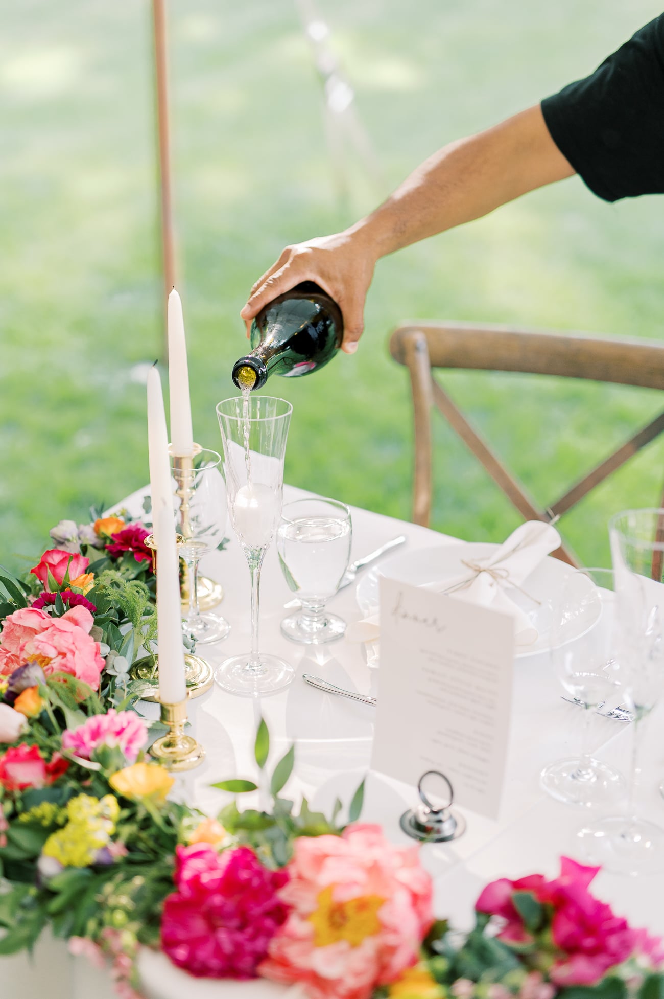 Pouring champagne into toasting glasses at sweetheart table