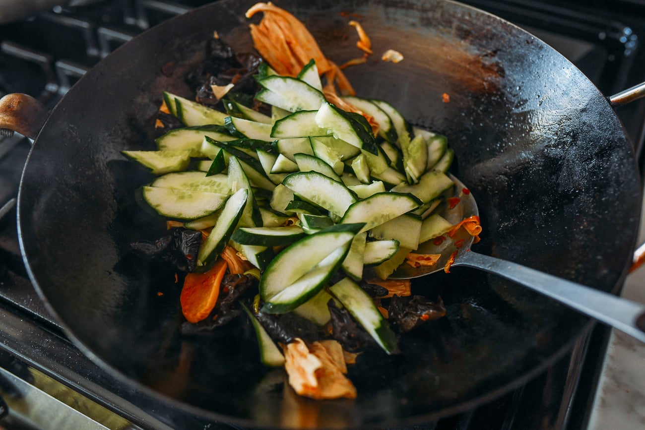 Adding cucumbers to wok