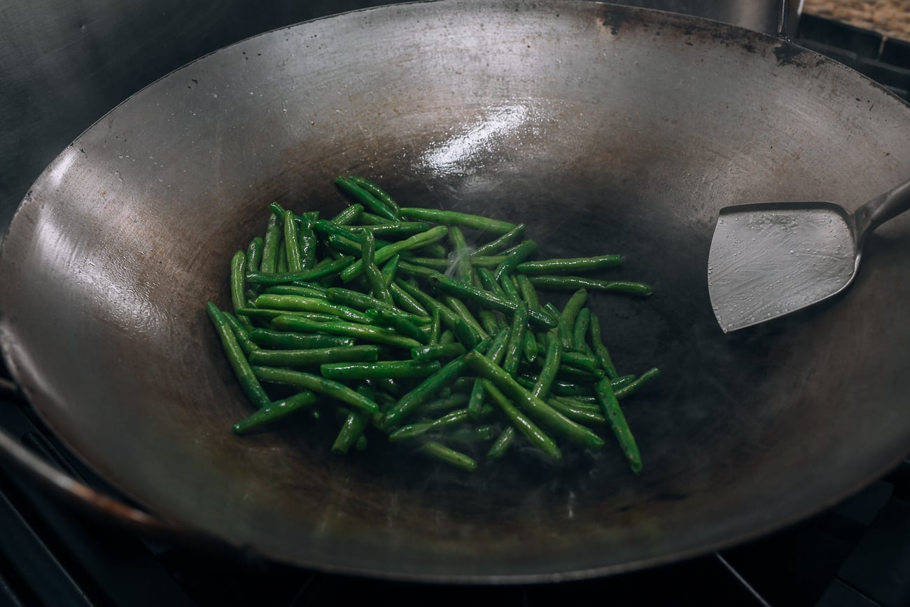Adding green beans to wok