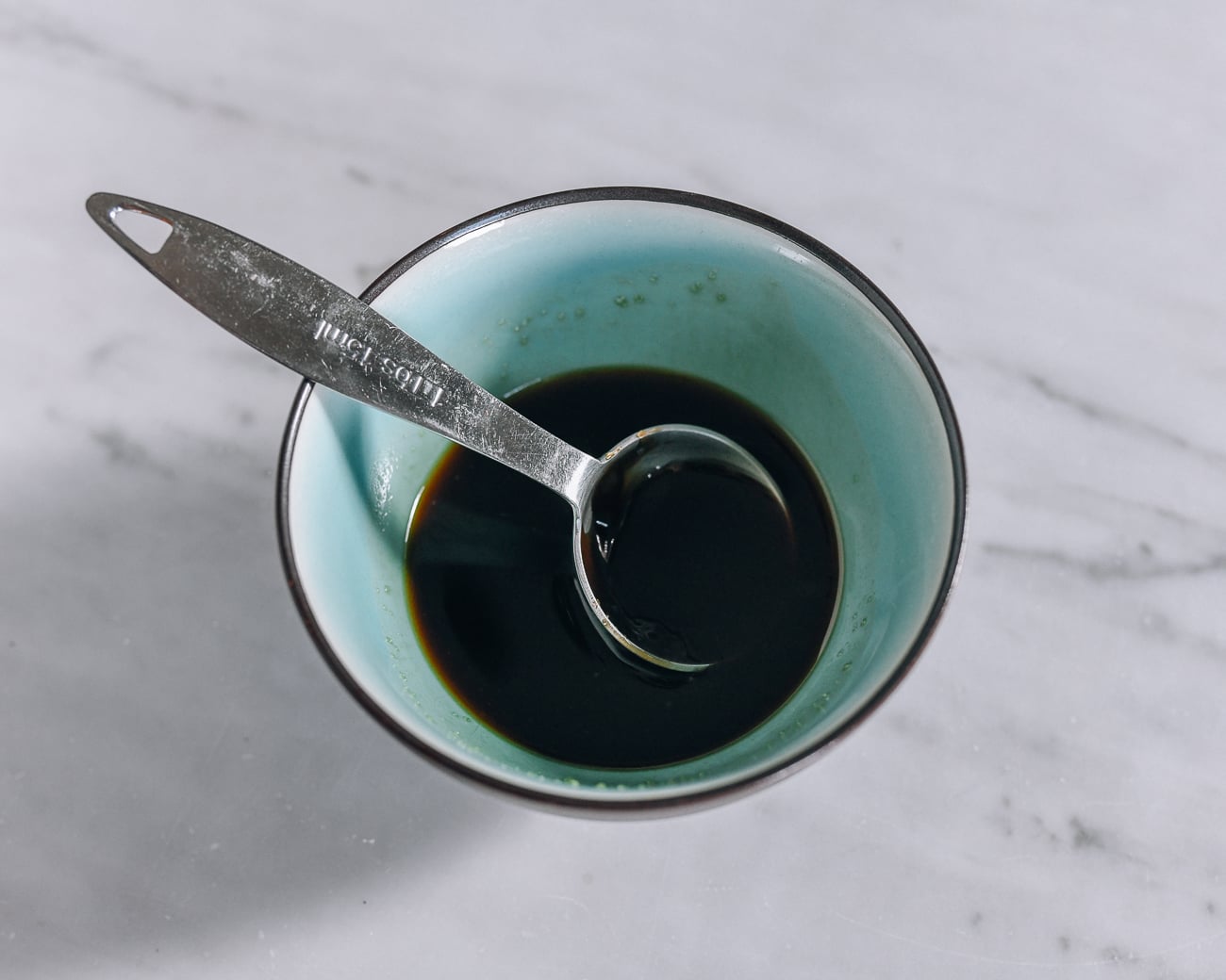 Sauce mixture in small bowl with measuring spoon