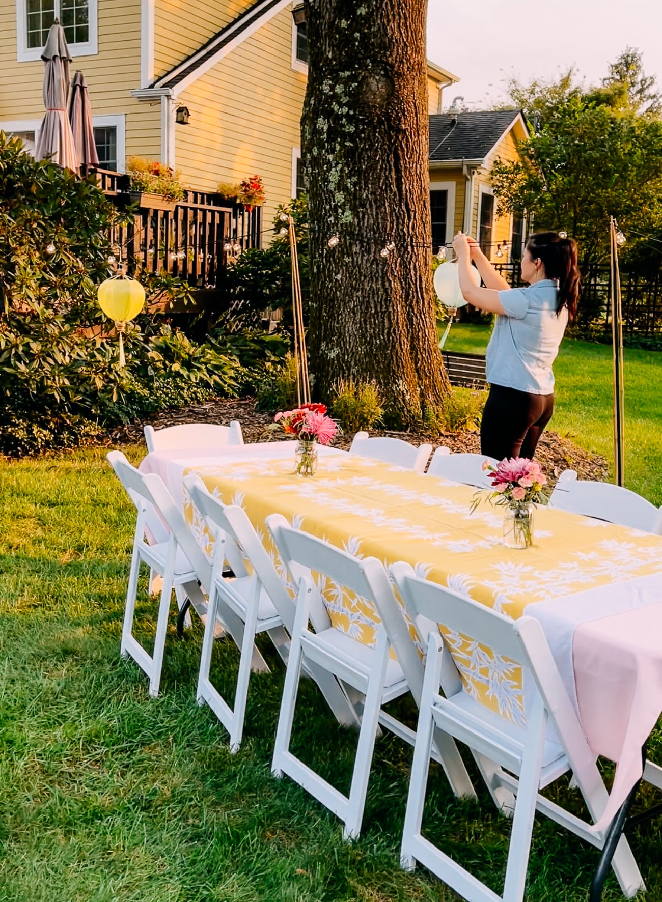 Sarah hanging lanterns in backyard