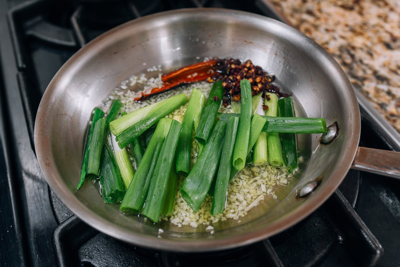 Scallions, garlic, and spices in saucepan with oil