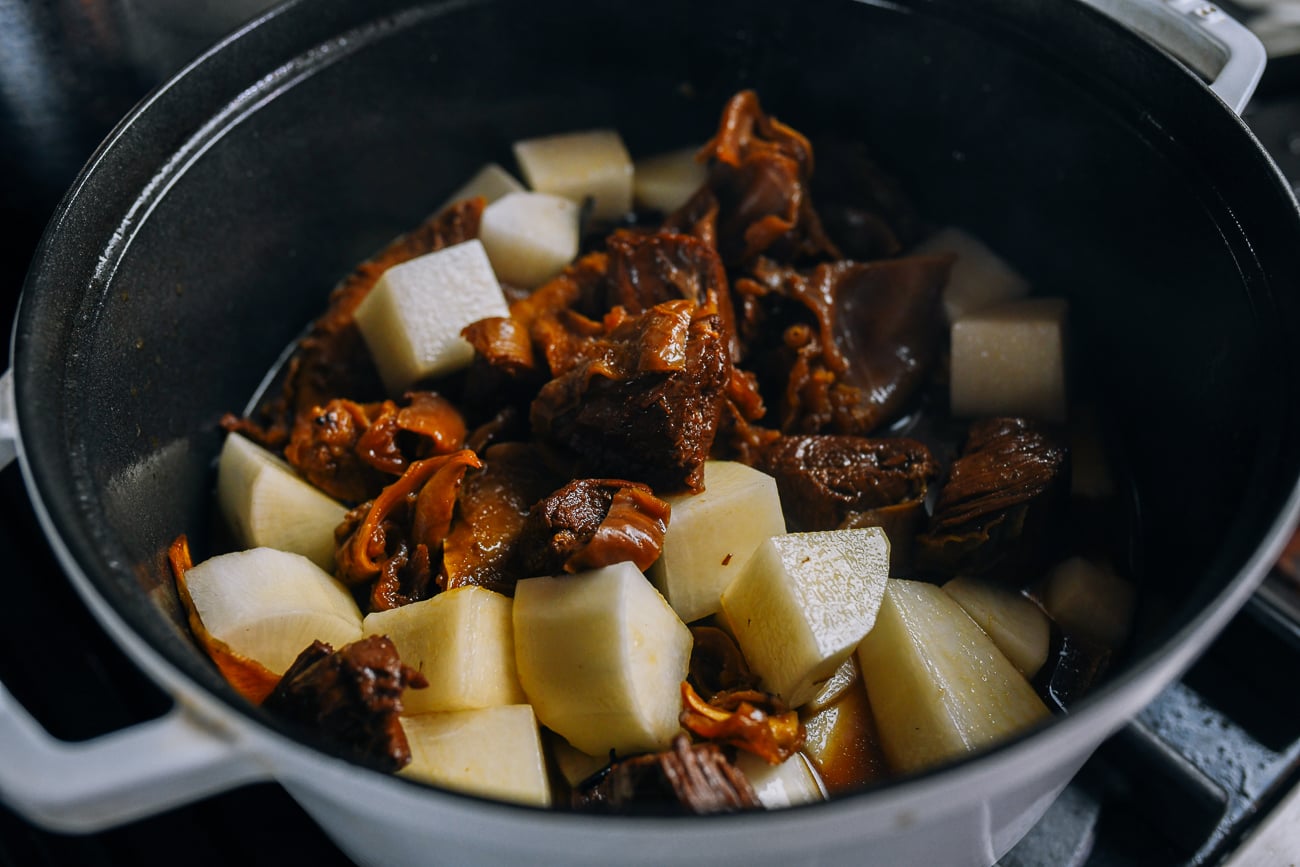 Stirring chunks of daikon into the stew