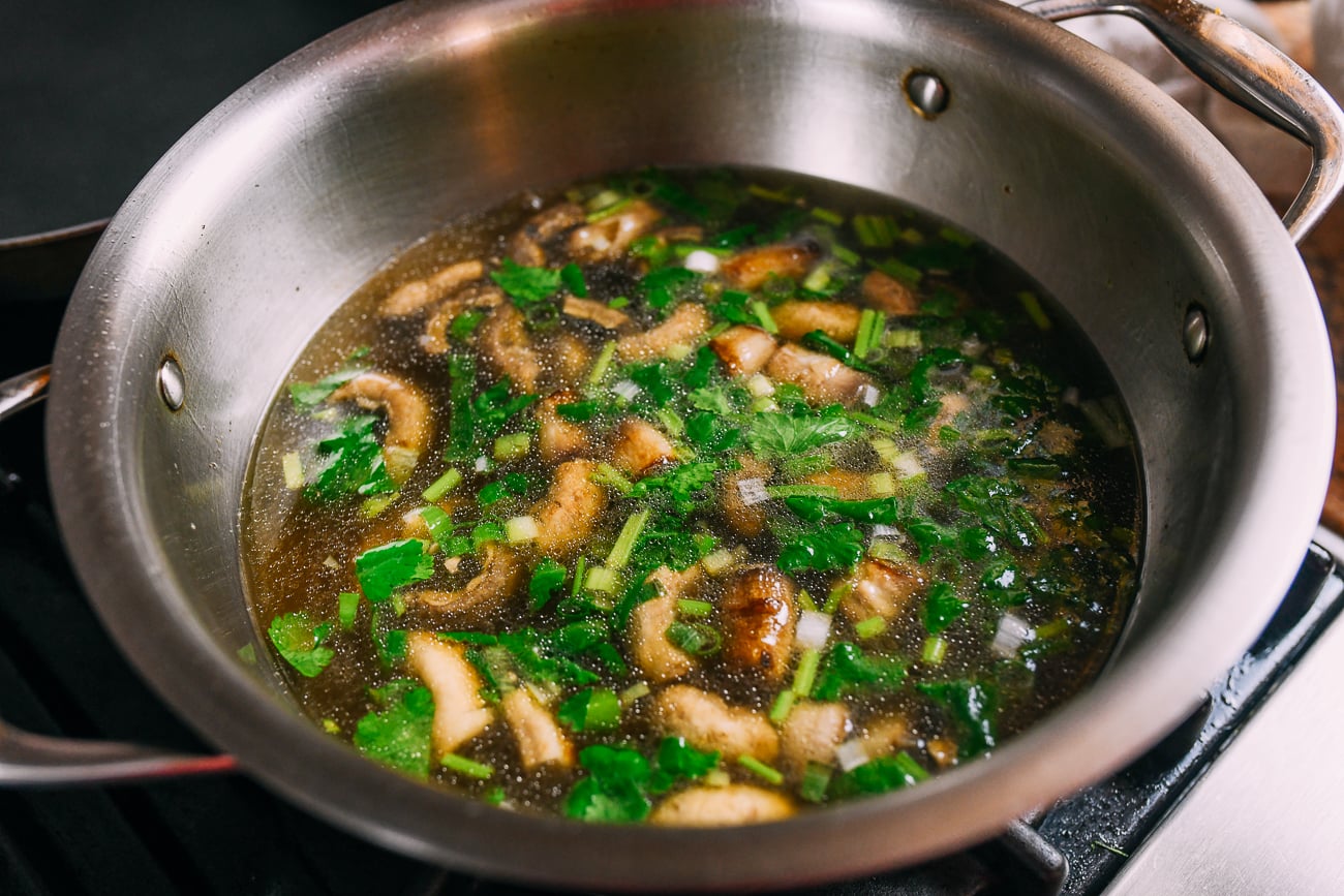 Pot of mushroom soup with scallions and cilantro