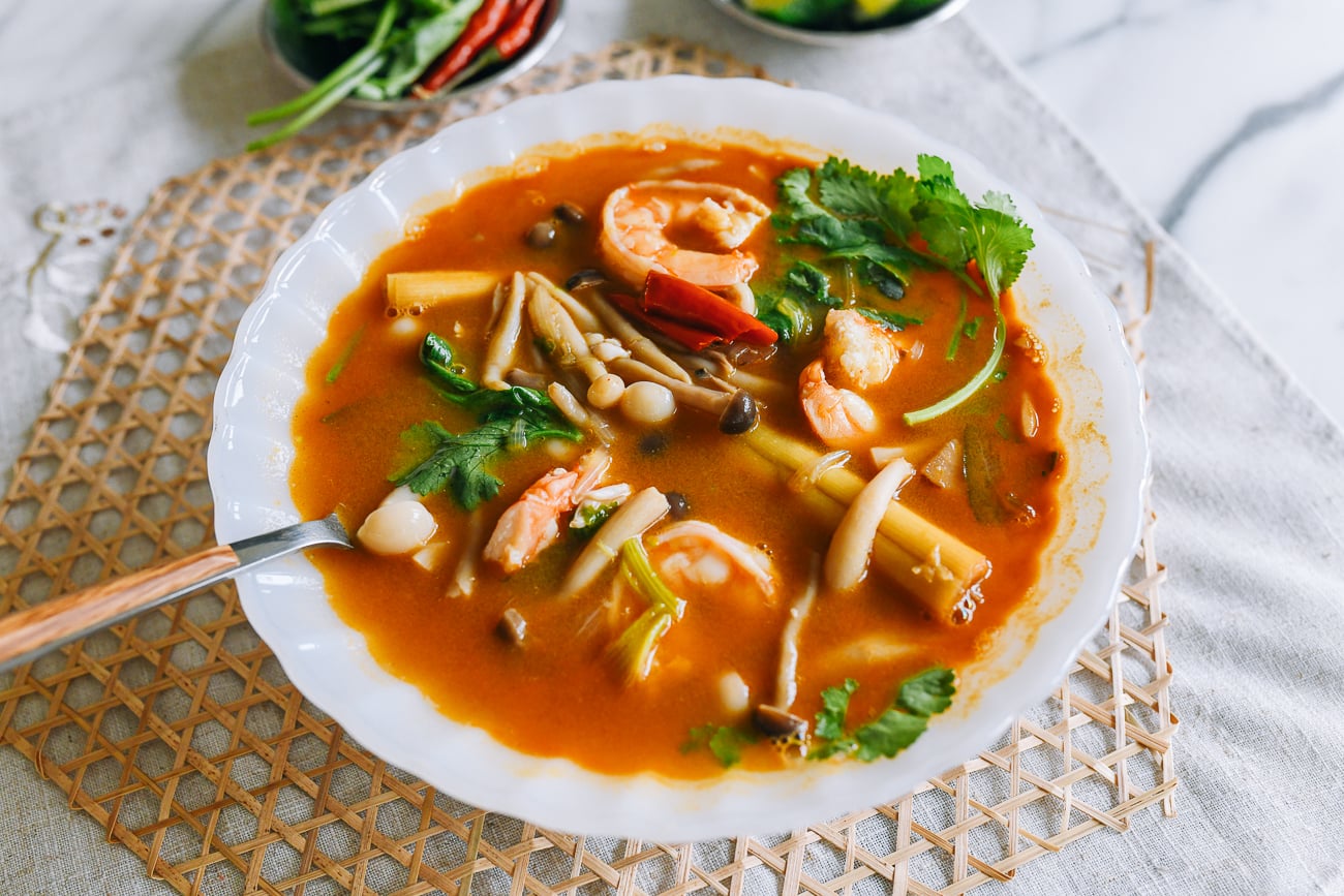 Spoon in bowl of tom yum soup with shrimp