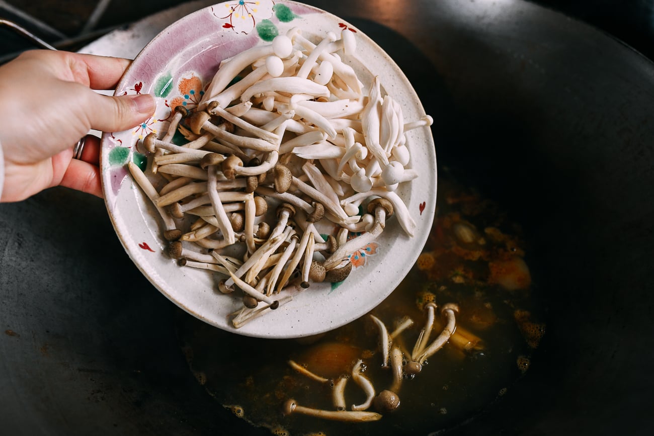 Adding mushrooms to tom yum soup