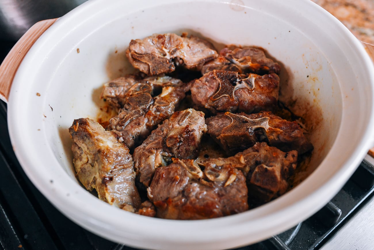Browning salted pork bones in pot
