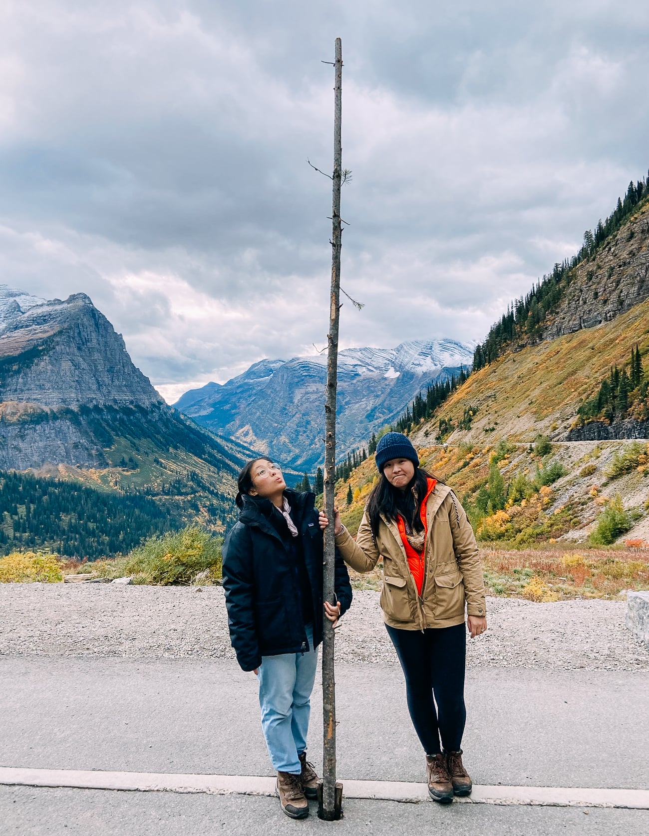 Sarah and Kaitlin next to a snow pole on the Going-to-the-Sun Road