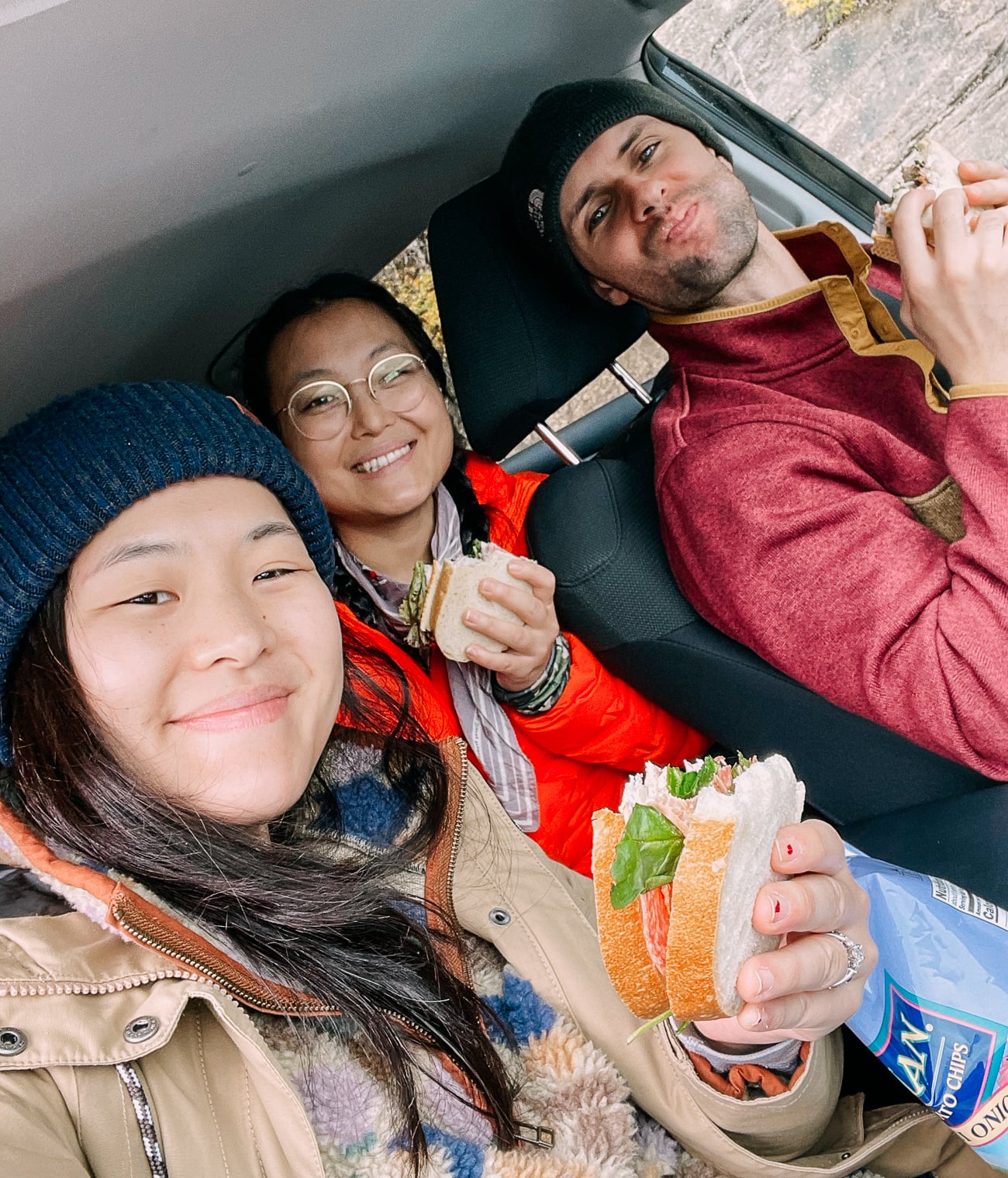 Sarah, Kaitlin, and Justin eating sandwiches in the car