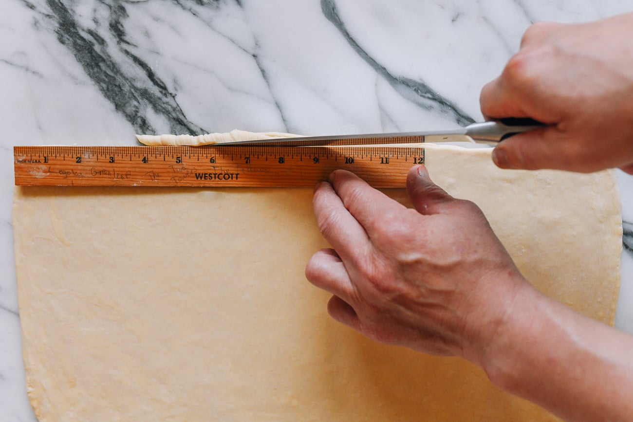 Trimming edges off croissant dough