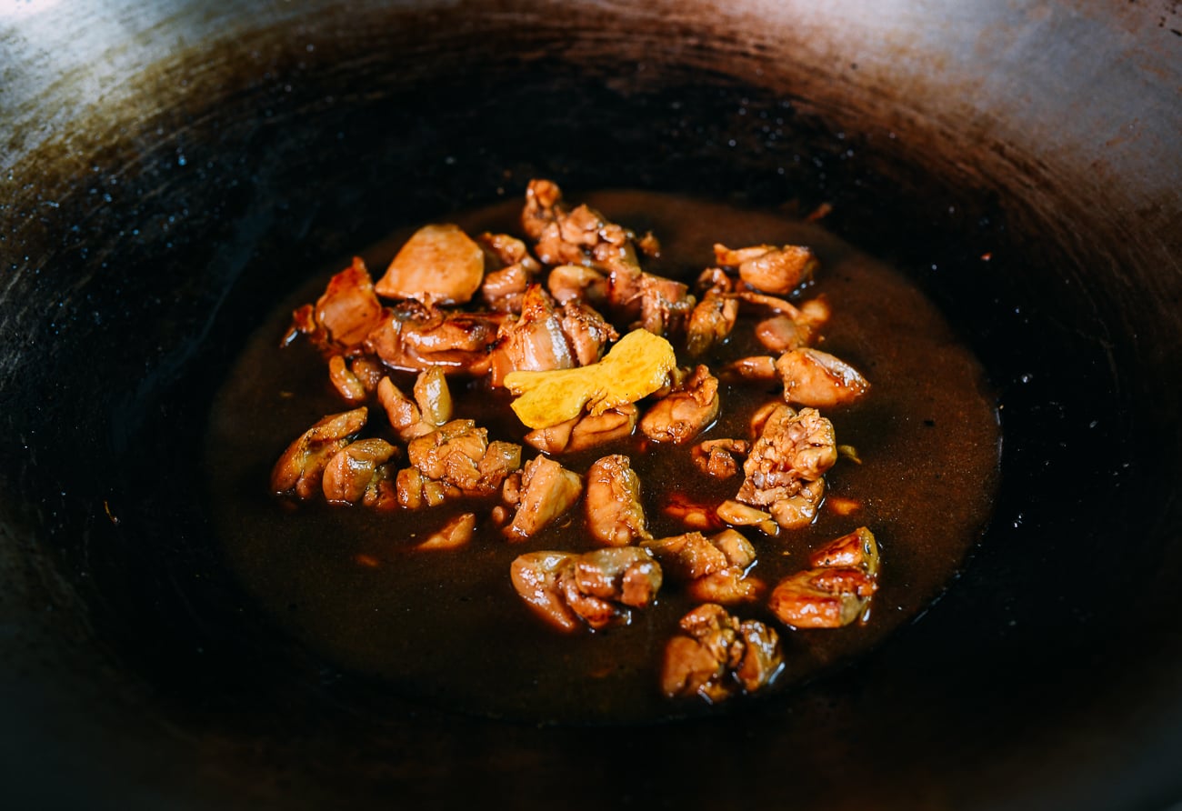 chicken pieces in wok with braising ingredients